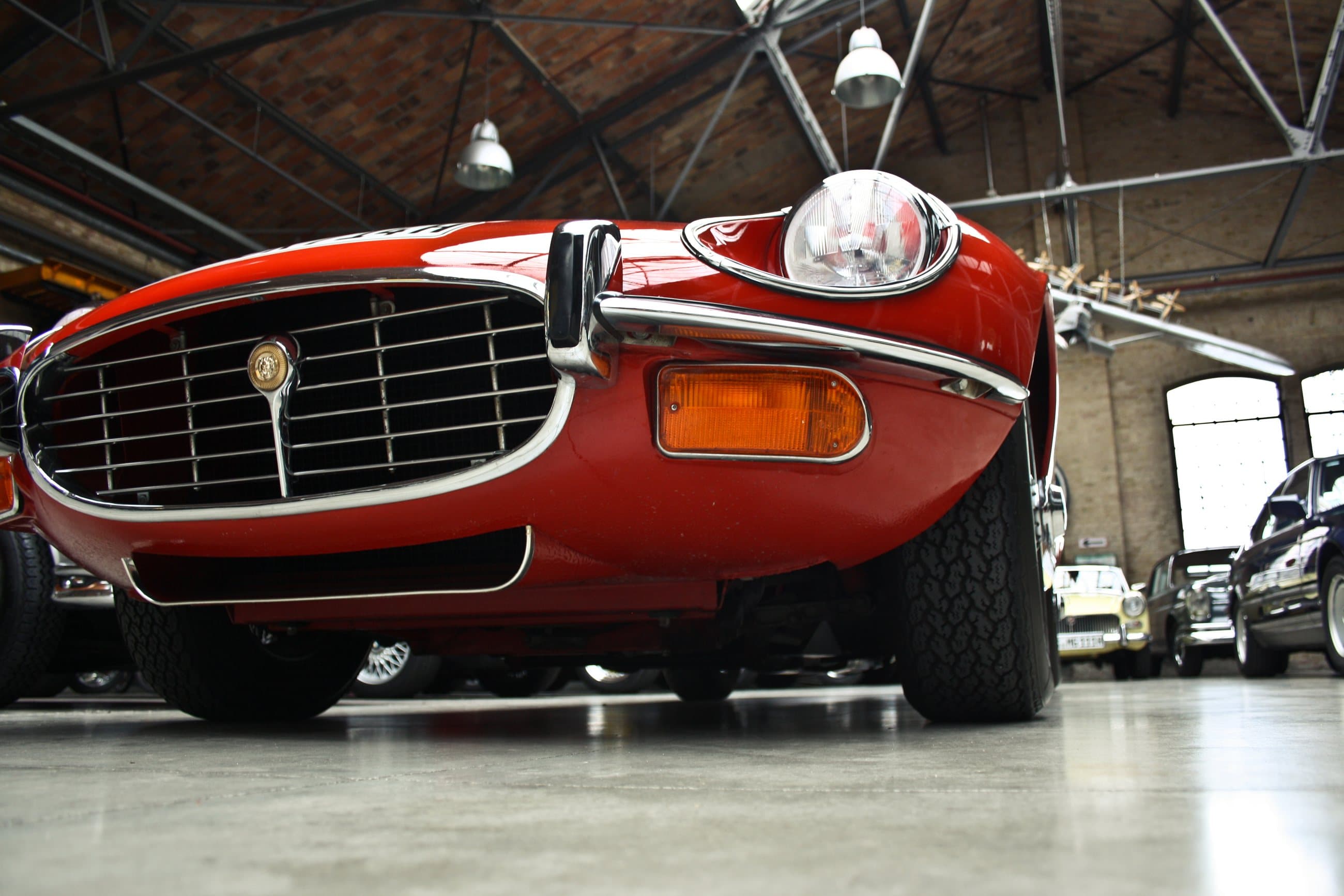 Front of a red Jaguar E-Type in a brick hall