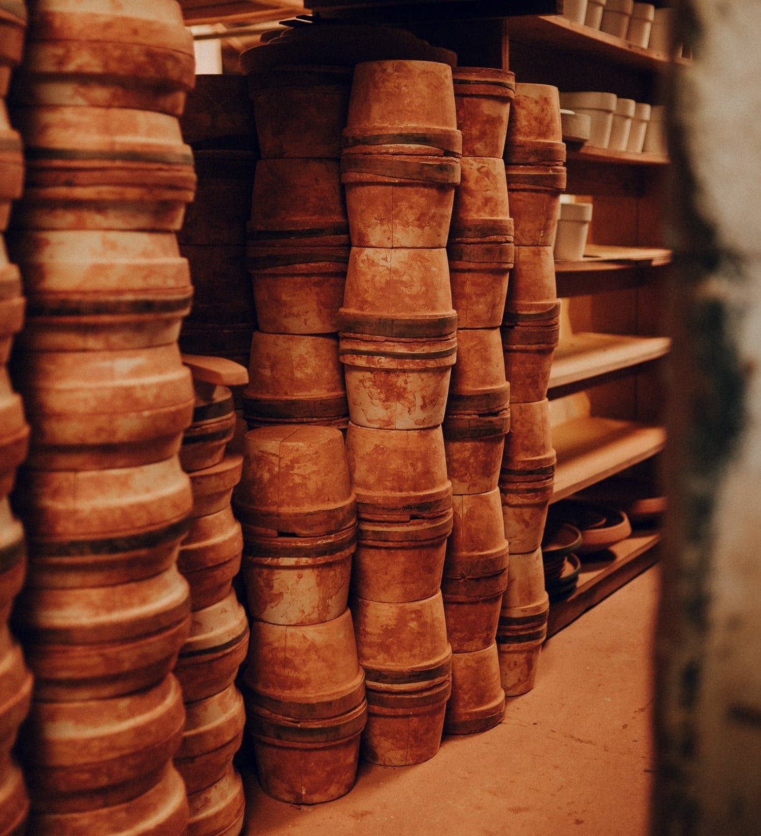 Stacks of terracotta pots on workshop shelves